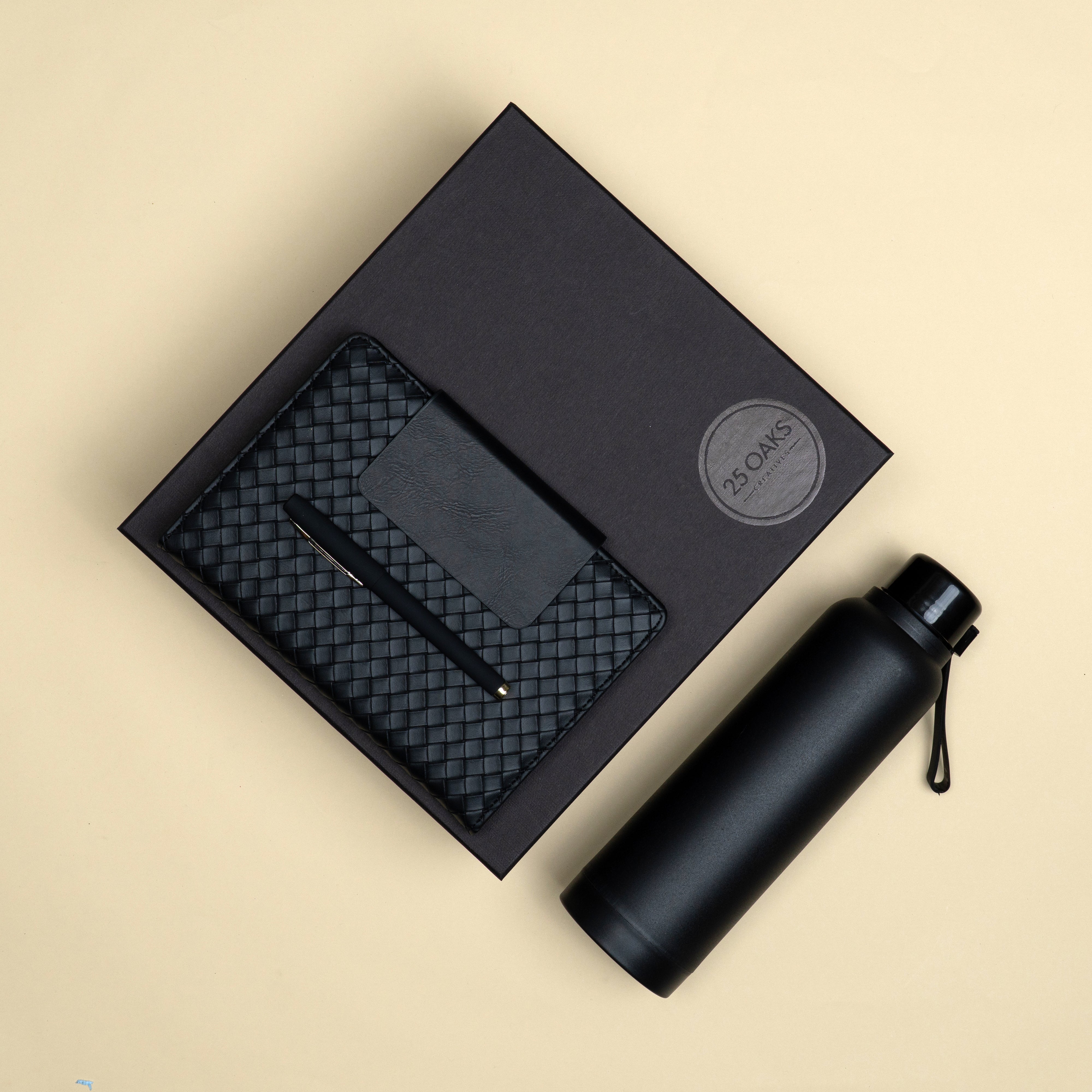 Premium black corporate gift set featuring a black bottle, black metallic pen and soft-cover diary packed in a luxury black gift box.