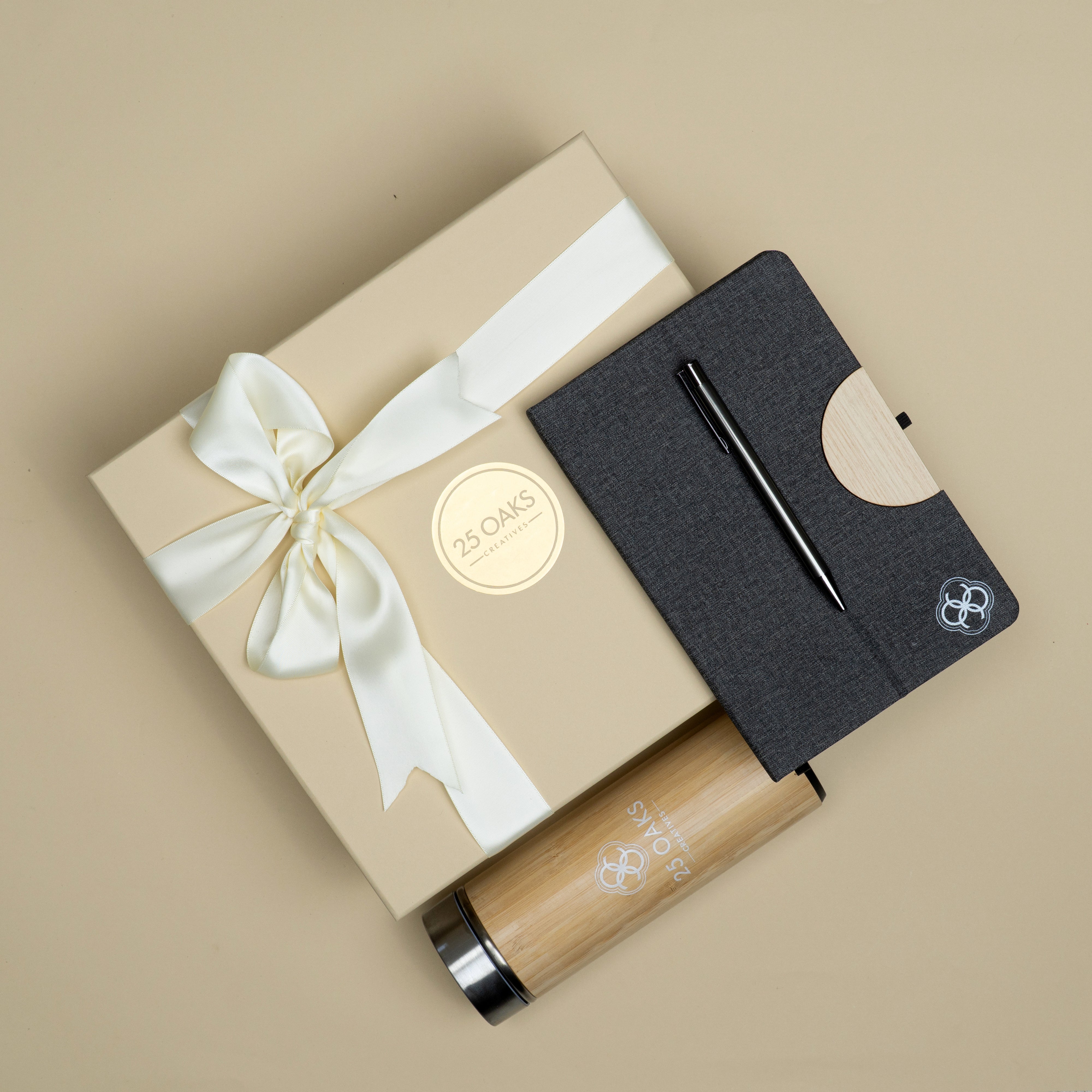 Premium corporate gifting set featuring a bamboo bottle, branded diary with phone stand and black metallic pen in luxury packaging.