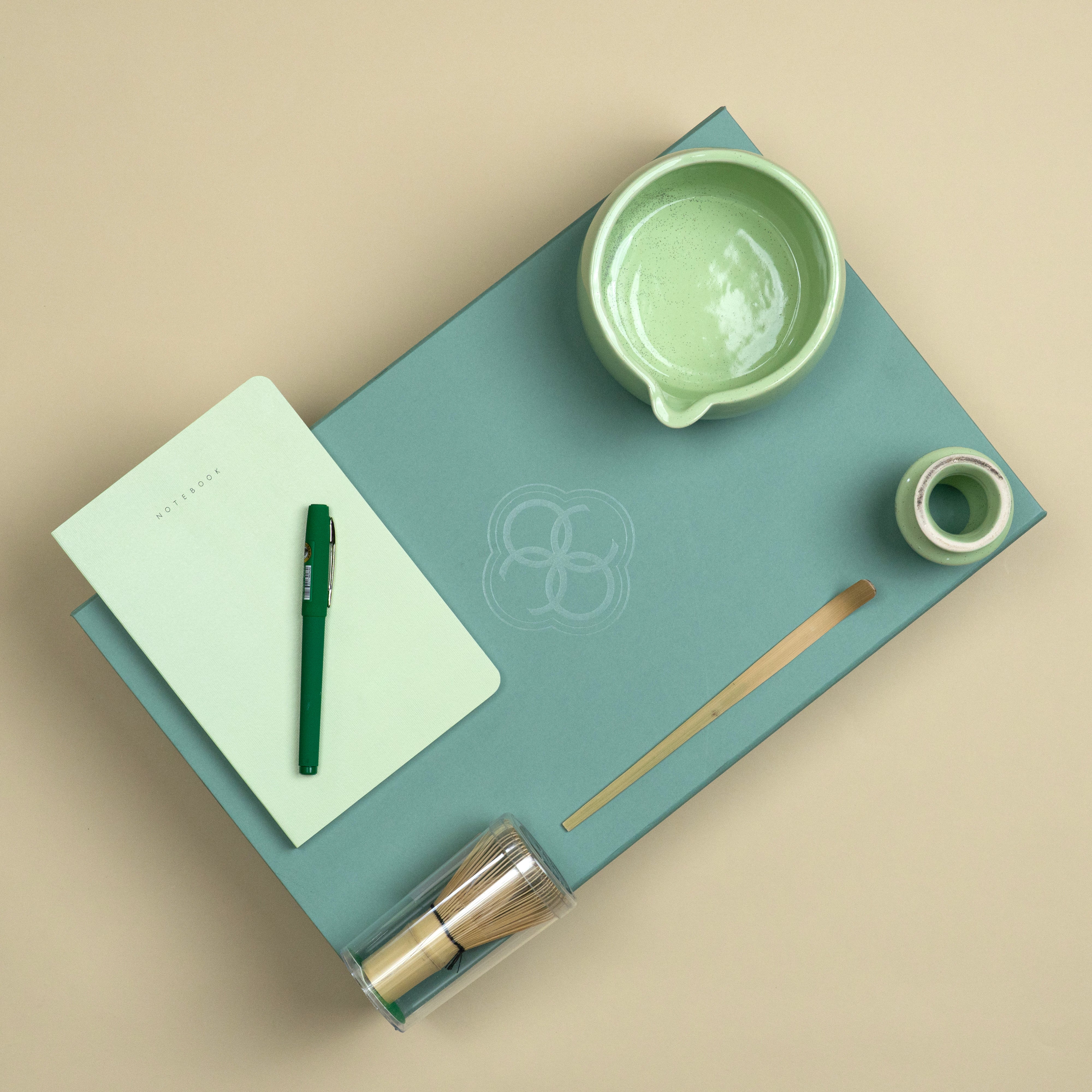 Premium corporate wellness gifting set featuring a green notebook, matte green pen, ceramic matcha set and wooden matcha accessories.