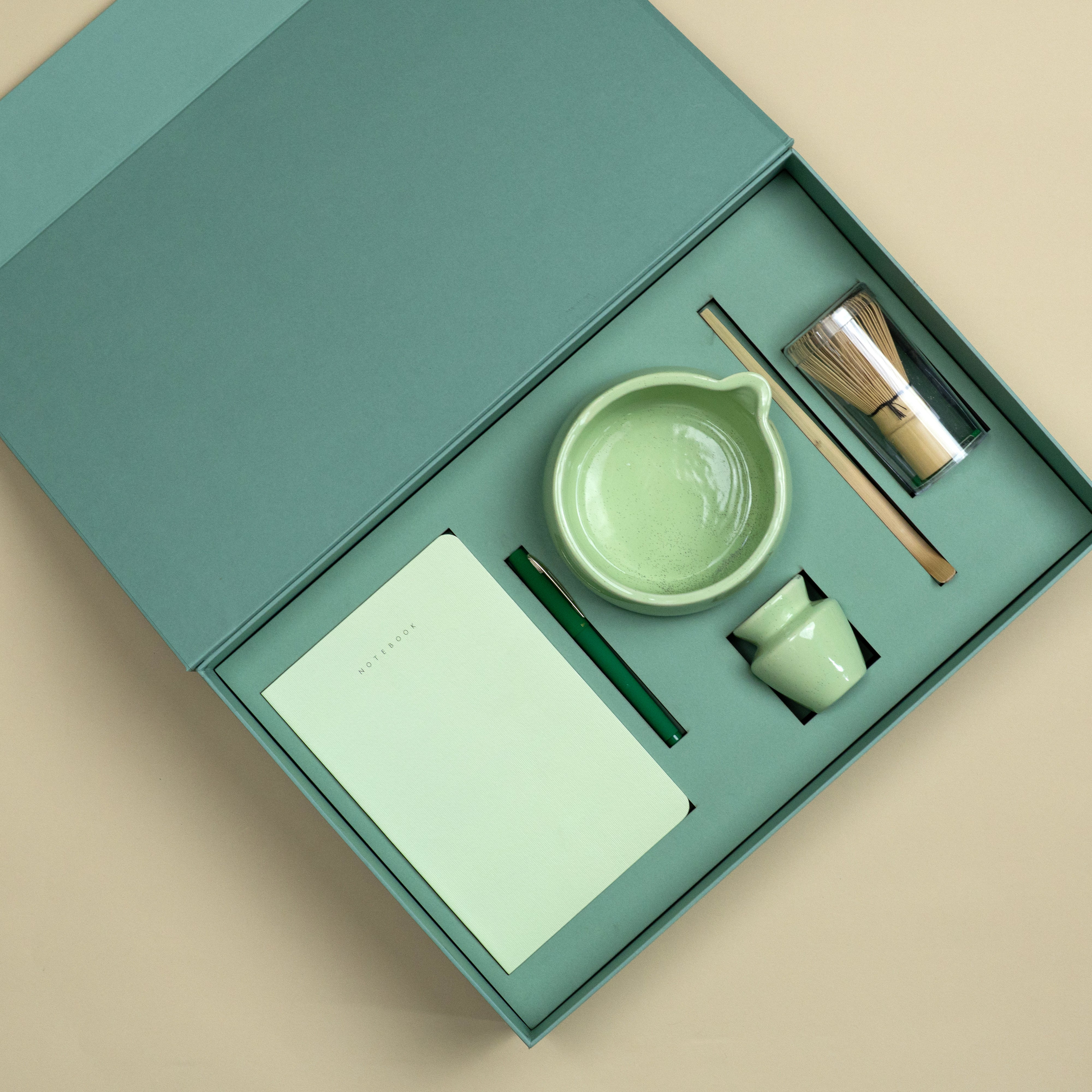 The Reset premium wellness gift set with A5 notebook, matte green pen, ceramic matcha bowl and wooden matcha accessories.