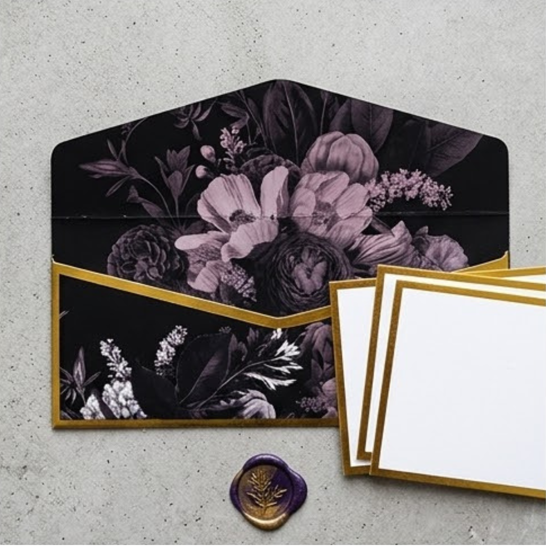 A sophisticated set of money envelopes in black, adorned with white and grey blooms and elegant gold details.