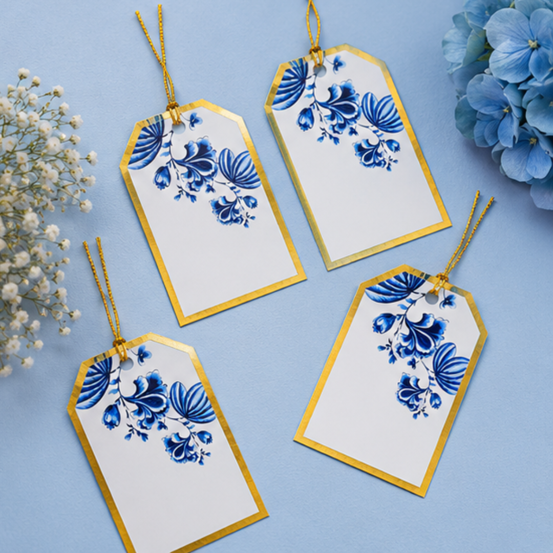 Luxury floral gift tags with golden strings and elegant blue artwork beautifully arranged in a soft pastel flat lay composition.