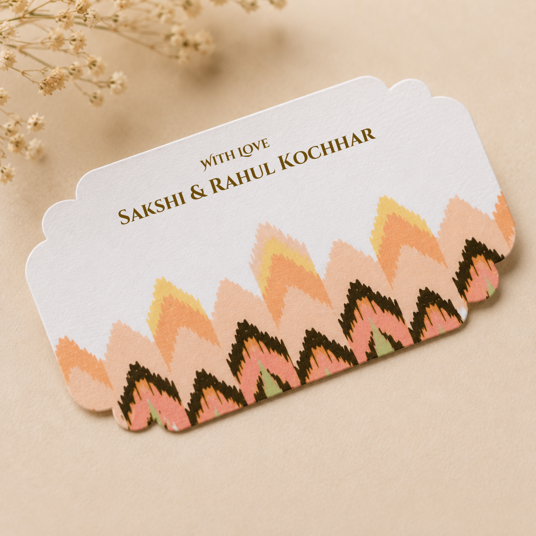 Sophisticated flat lay of pastel patterned peel and stick gift tags arranged in stacked and scattered styling with elegant neutral props.
