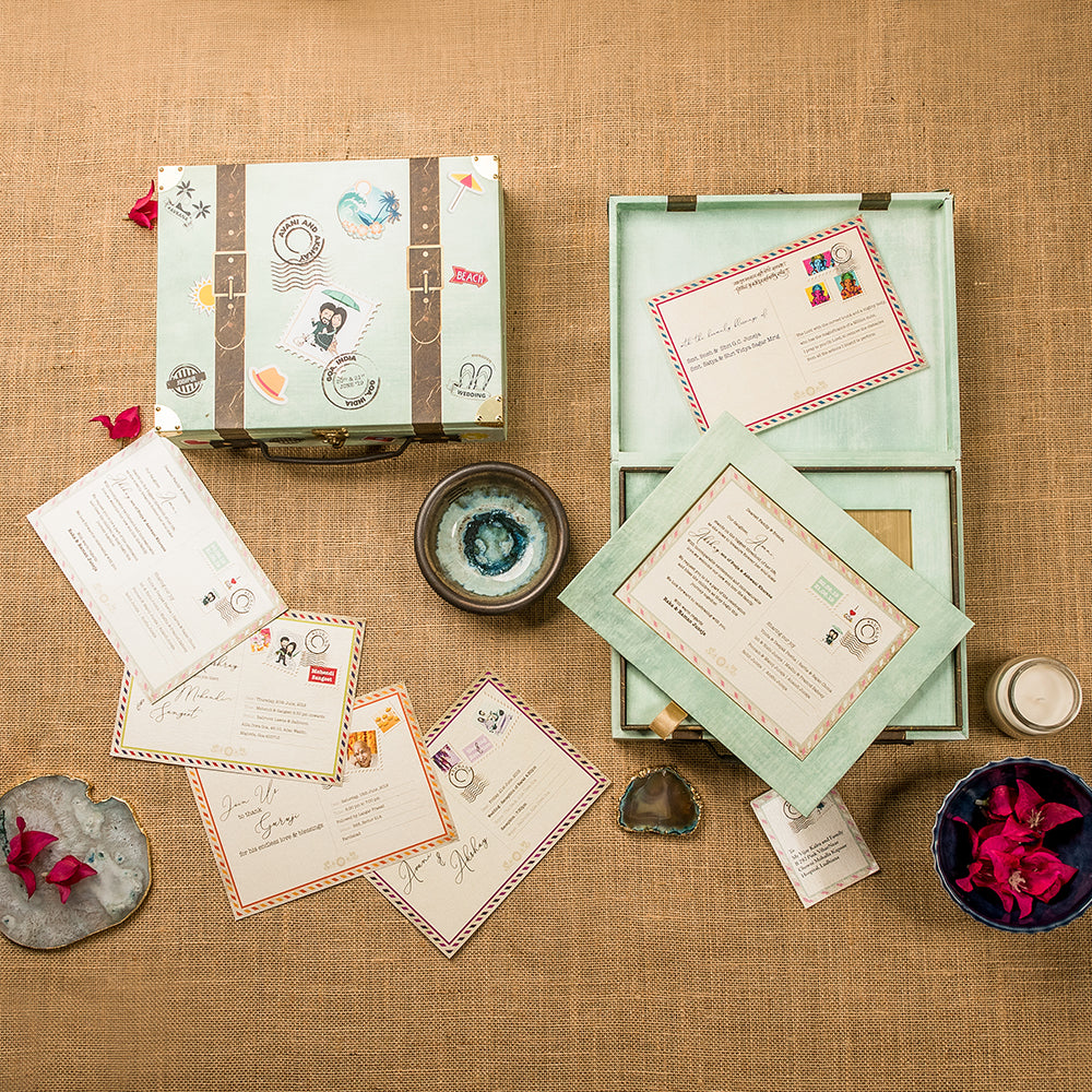 Travel-themed wedding invite set with vintage suitcase box