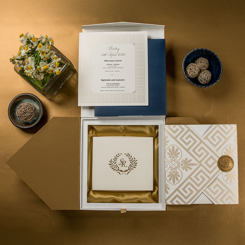 Royal blue and gold wedding invite with Greco-Indian patterns and satin-lined invitation box.