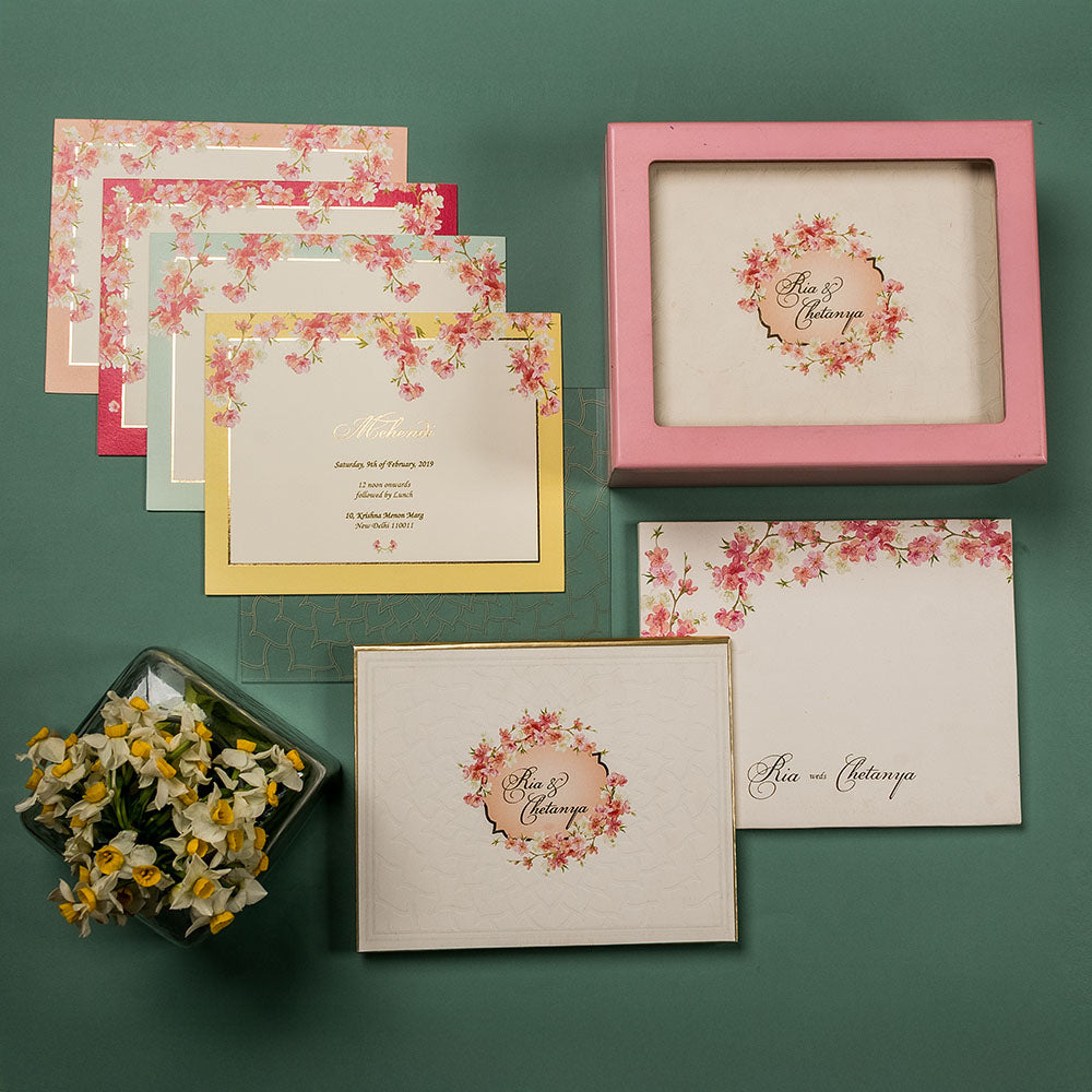 Floral pastel wedding invite set with pink cherry blossom design and personalized invitation box.