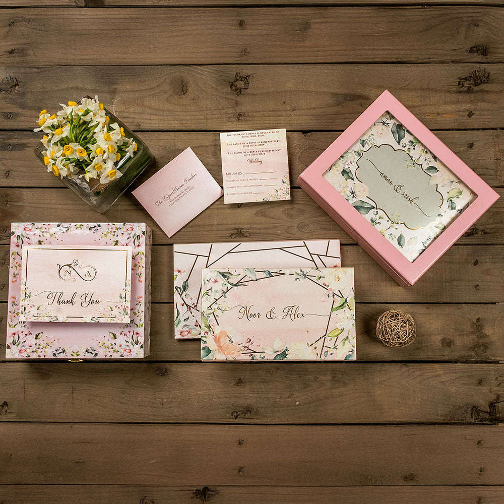 Pastel blush wedding invite with botanical print, personalized box, and elegant inserts.
