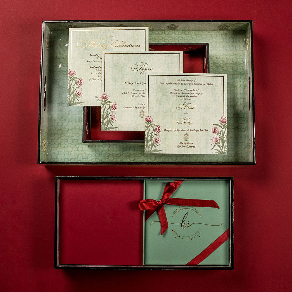 Luxury Mughal-theme invitation box with detailed inserts and red velvet ribbon detailing.