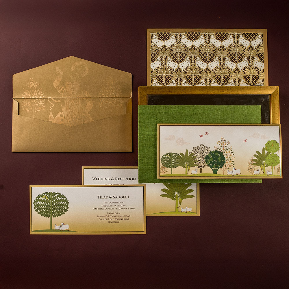Pichwai-inspired wedding invitation set with forest and cow motifs