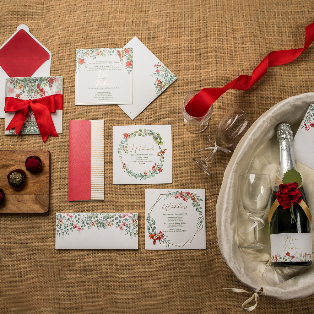 Floral wedding invitation set with red ribbon and bottle