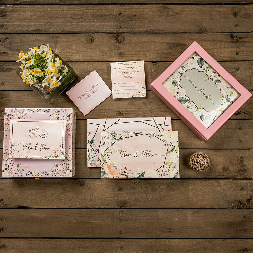Soft pink floral wedding invitation set with botanical illustrations and thank you card.
