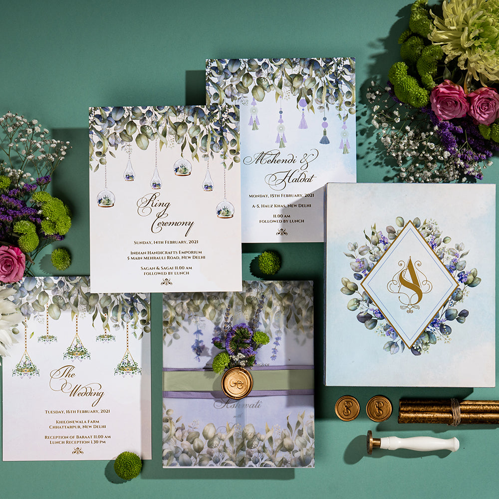 Eucalyptus and lavender wedding invite with vellum wrap, tassels, and wax seal.