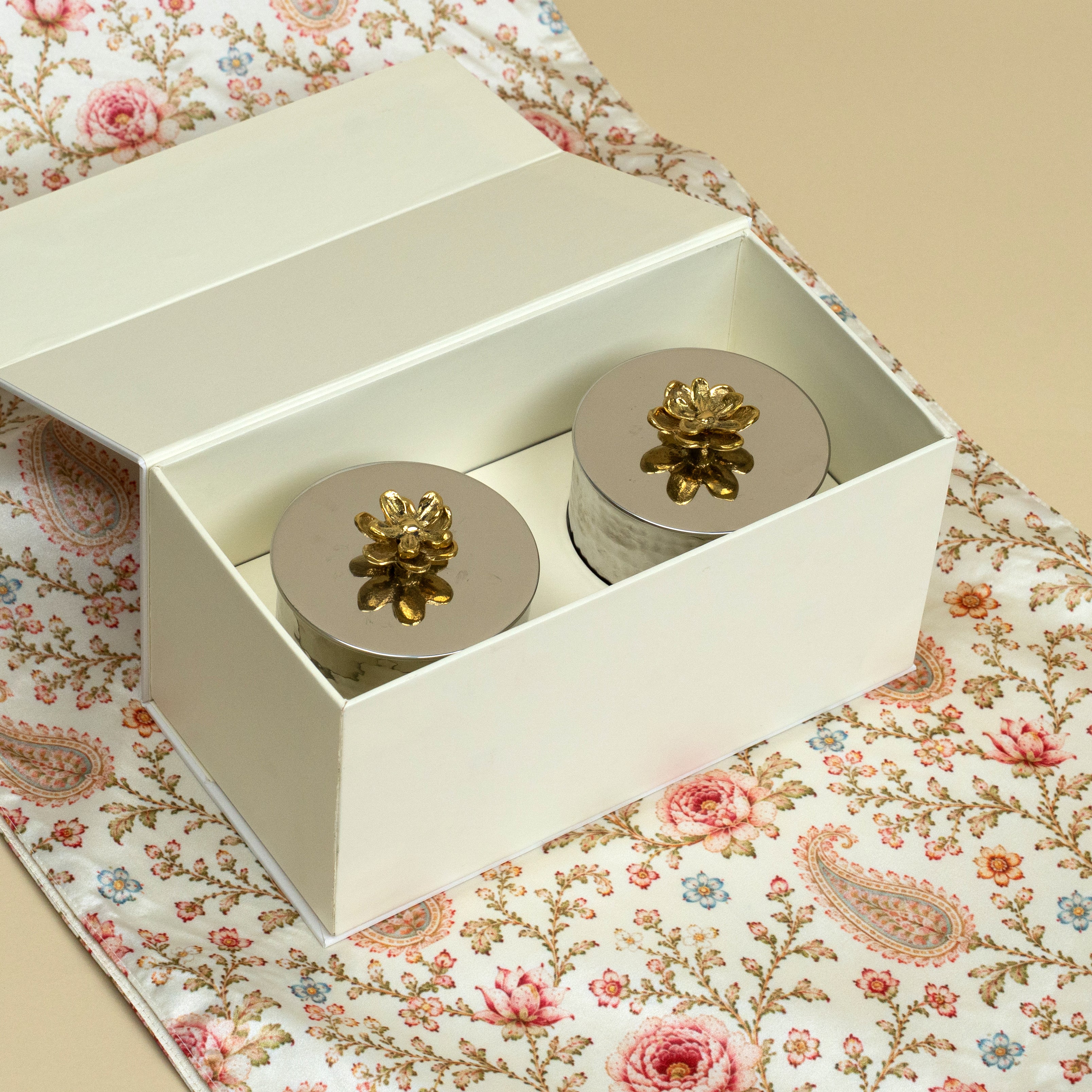 Set of 2 Velvet Rose Oud scented candles arranged on a printed table runner