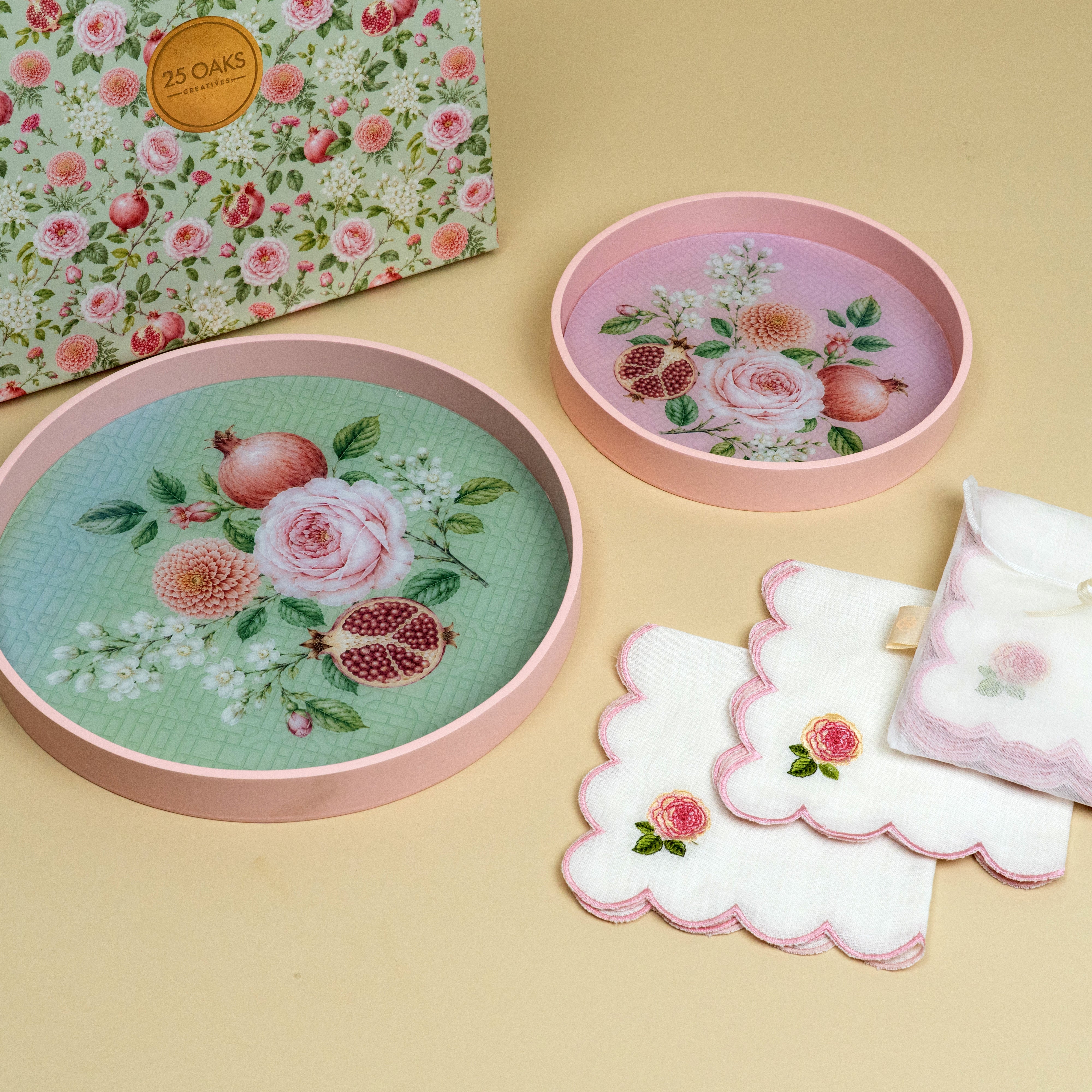 Two pink round serving trays with floral prints and matching festive table accessories