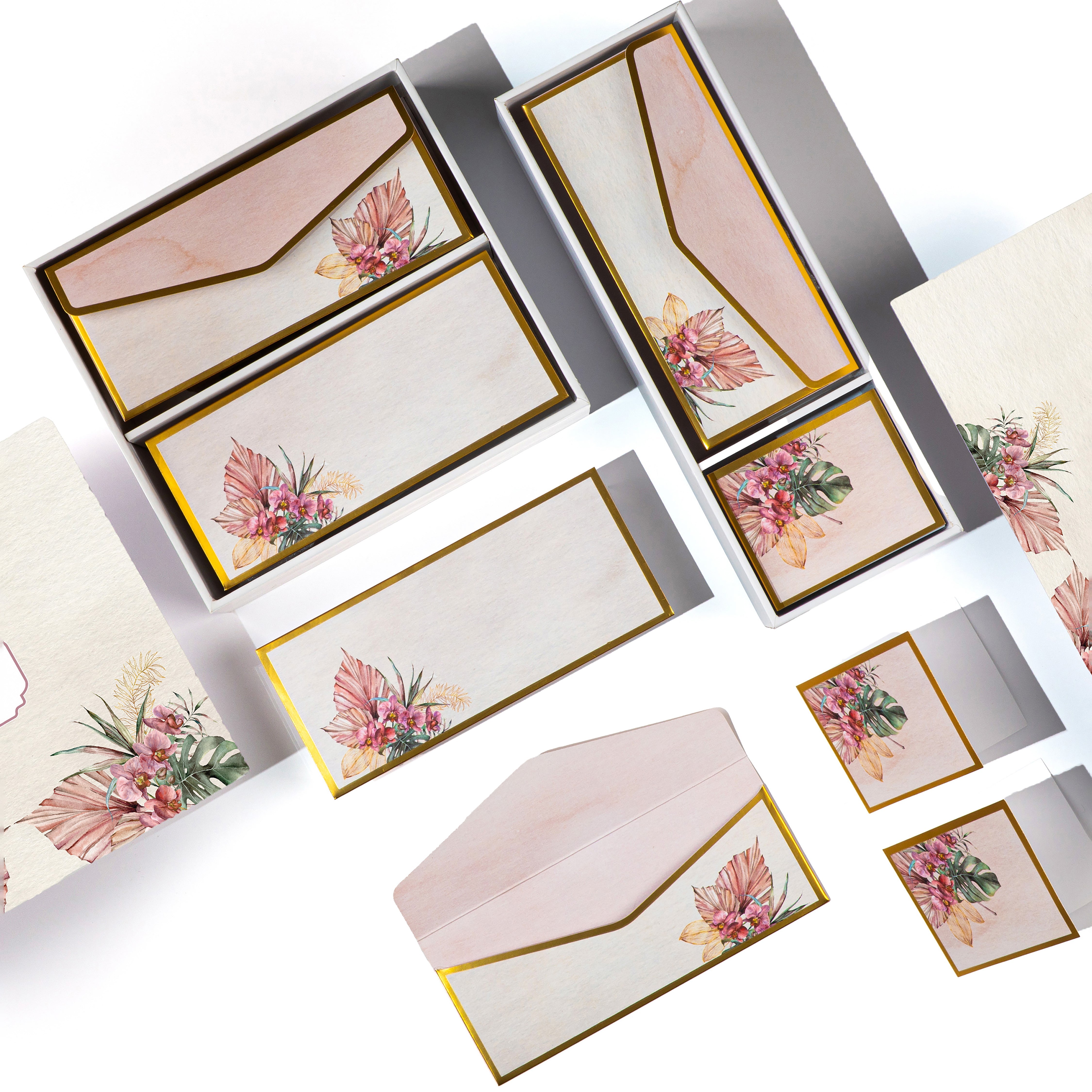 Tropical floral stationery set with gold accents, featuring tags, cards, and envelopes in a wooden-look box.