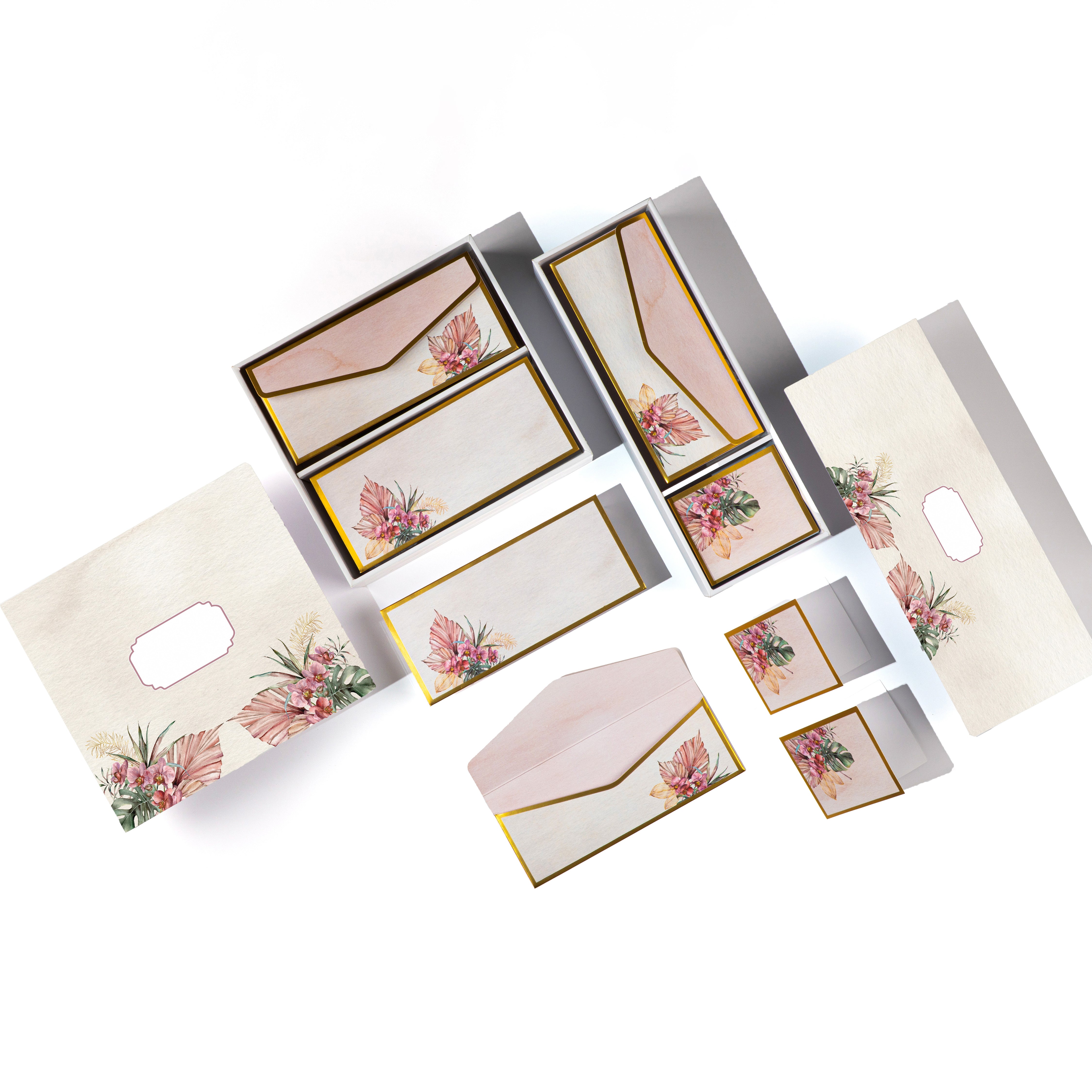 Tropical floral stationery set with gold accents, featuring tags, cards, and envelopes in a wooden-look box.