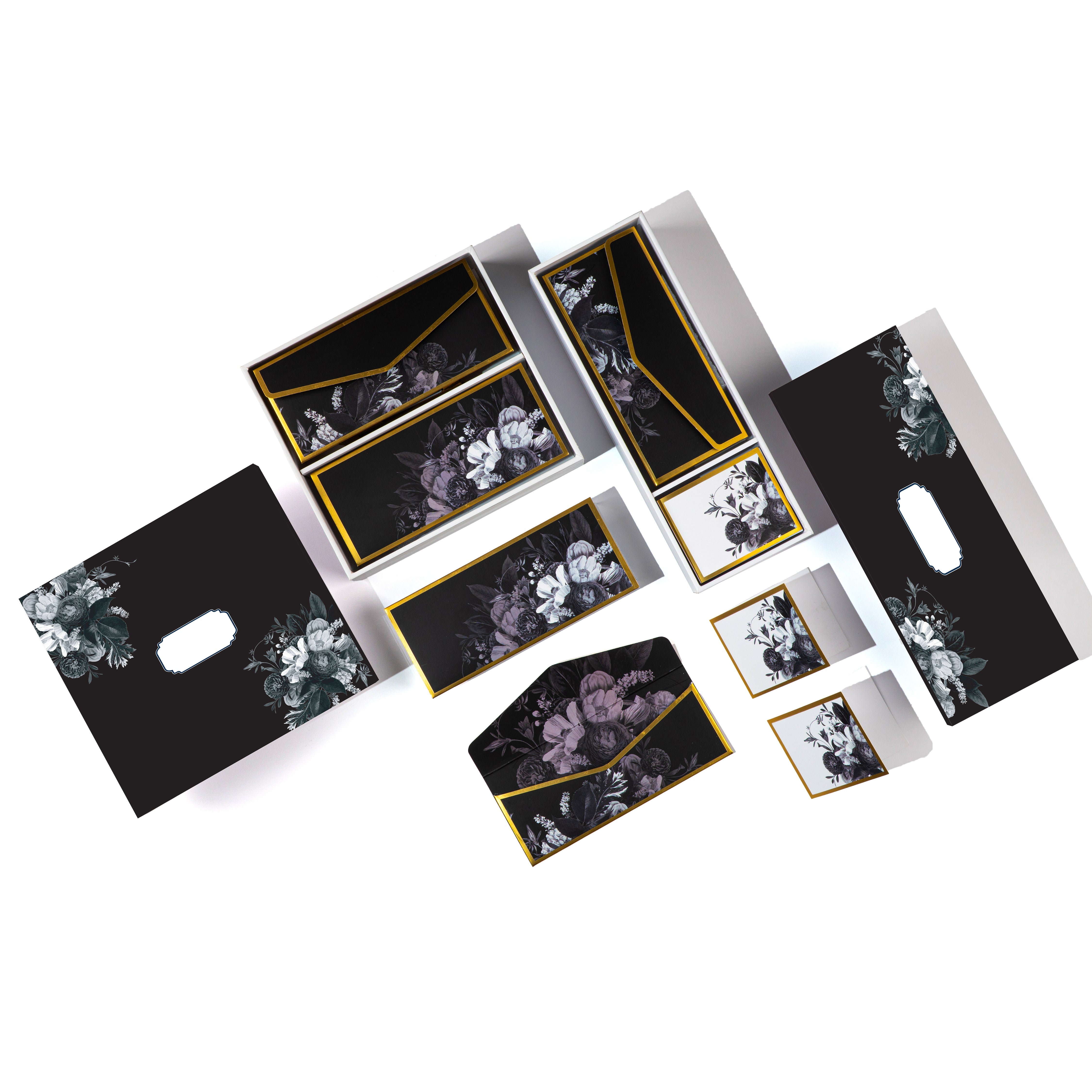 Luxury black floral stationery set with envelopes, cards, and boxes featuring gold trim and elegant botanical designs.