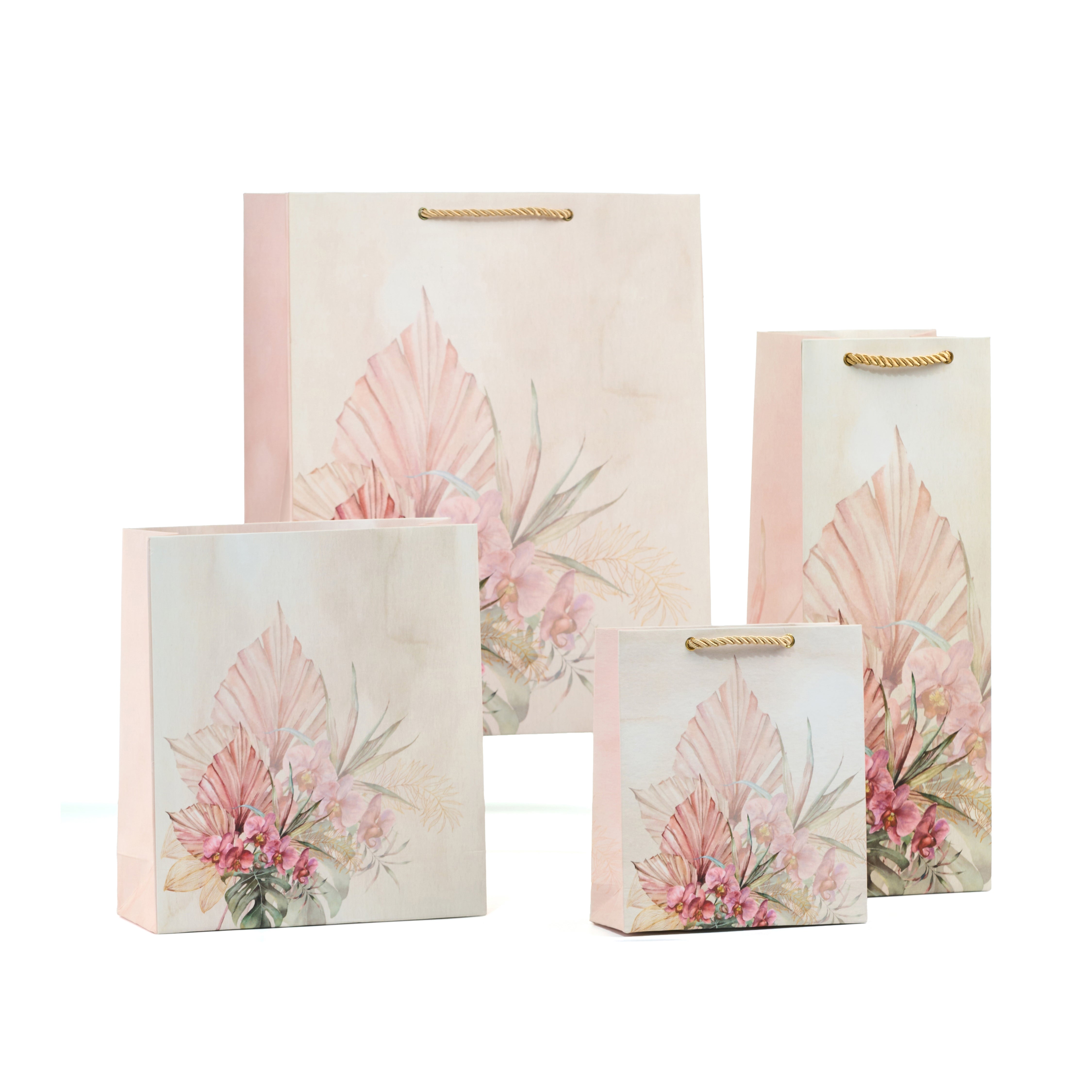 A pastel pink gift bag adorned with a sophisticated botanical floral design, combining soft pink leaves and delicate watercolor flowers, available in multiple sizes.