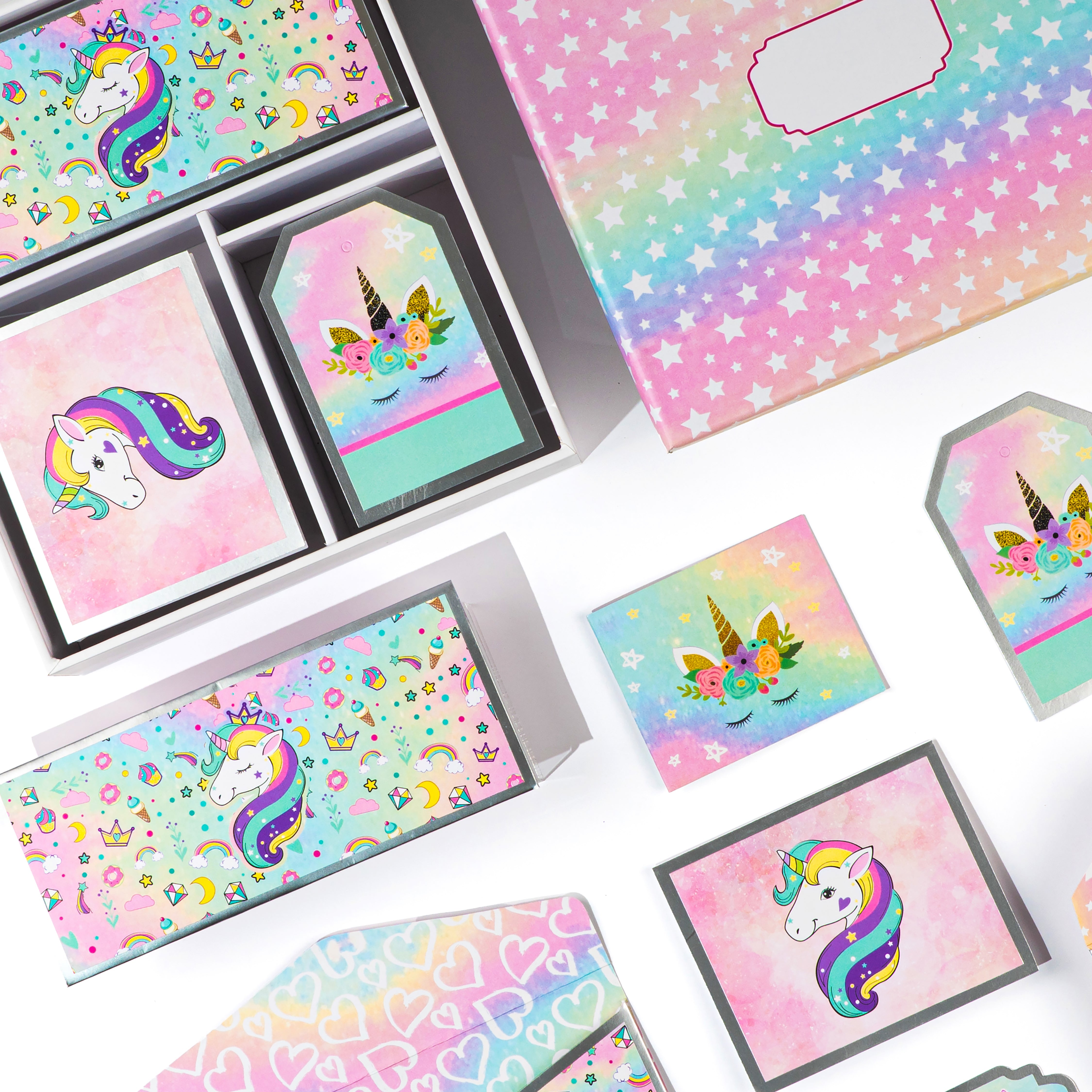 Colorful kids stationery box featuring unicorn illustrations, star patterns, pastel envelopes, cards, and decorative tags.