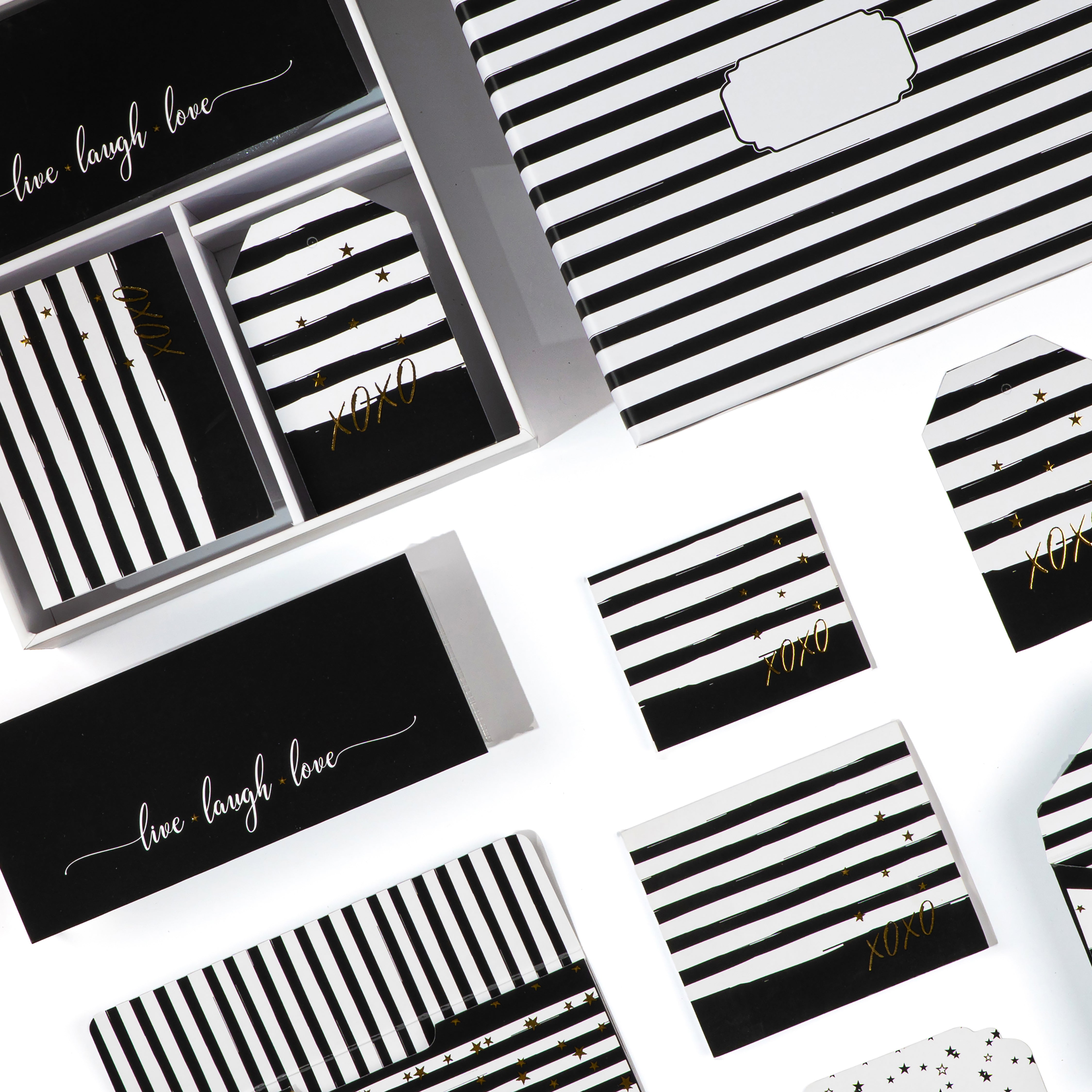 Black-and-white striped stationery set featuring “XOXO” accents and gold‑foil stars.