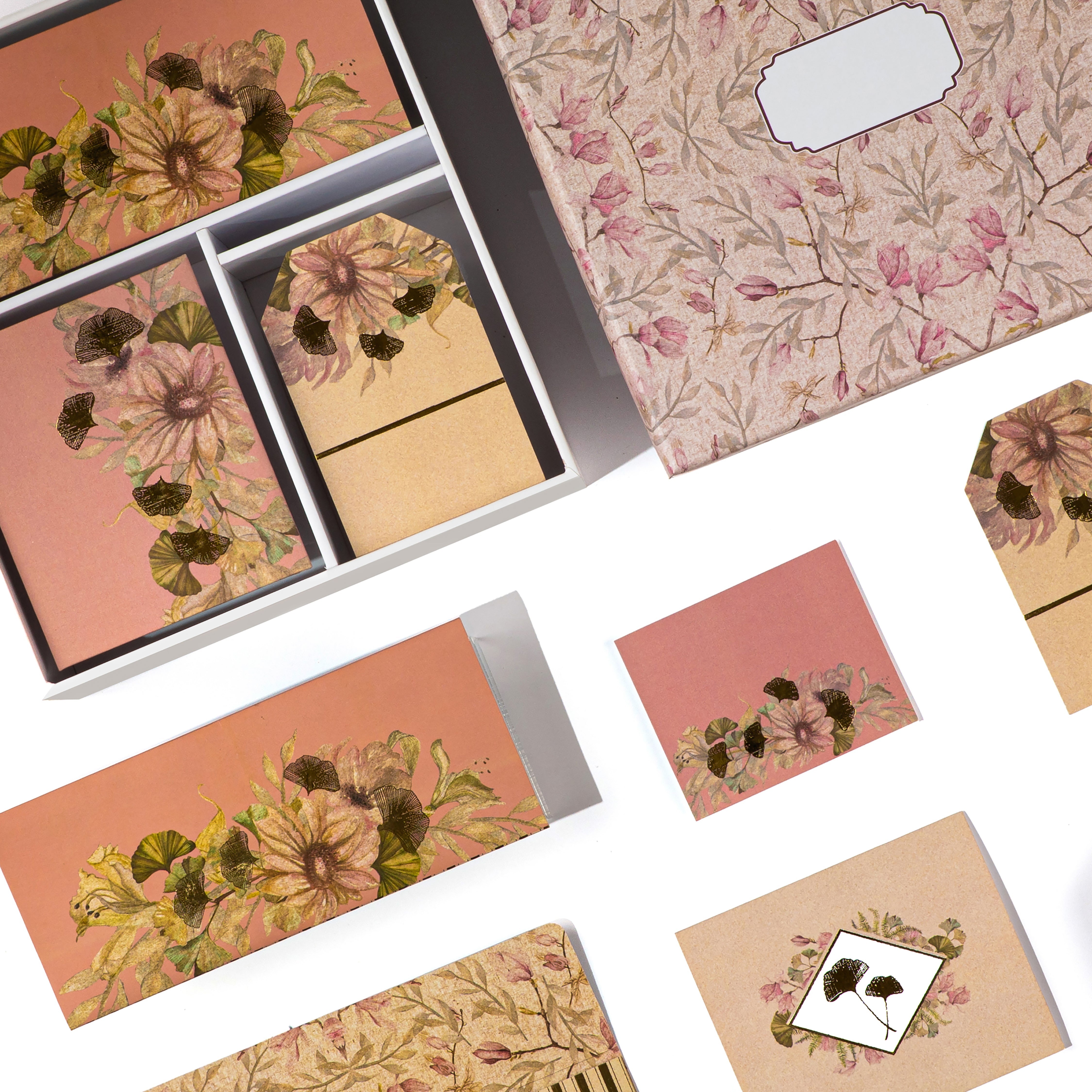 Soft pink stationery box with gold-accented floral designs and matching cards and tags.