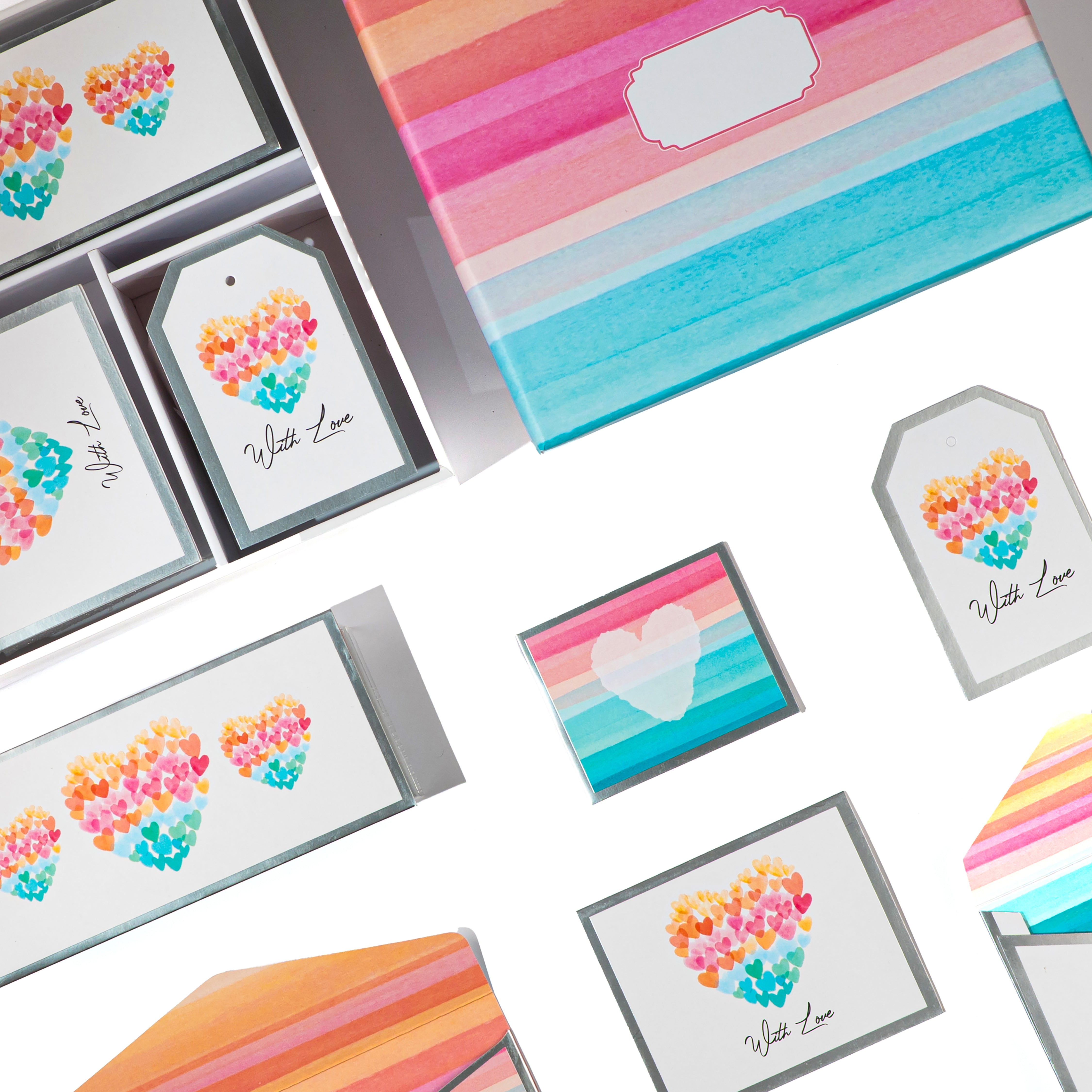 Colorful luxury stationery box featuring heart artwork, rainbow watercolor stripes, envelopes, cards, and decorative tags.