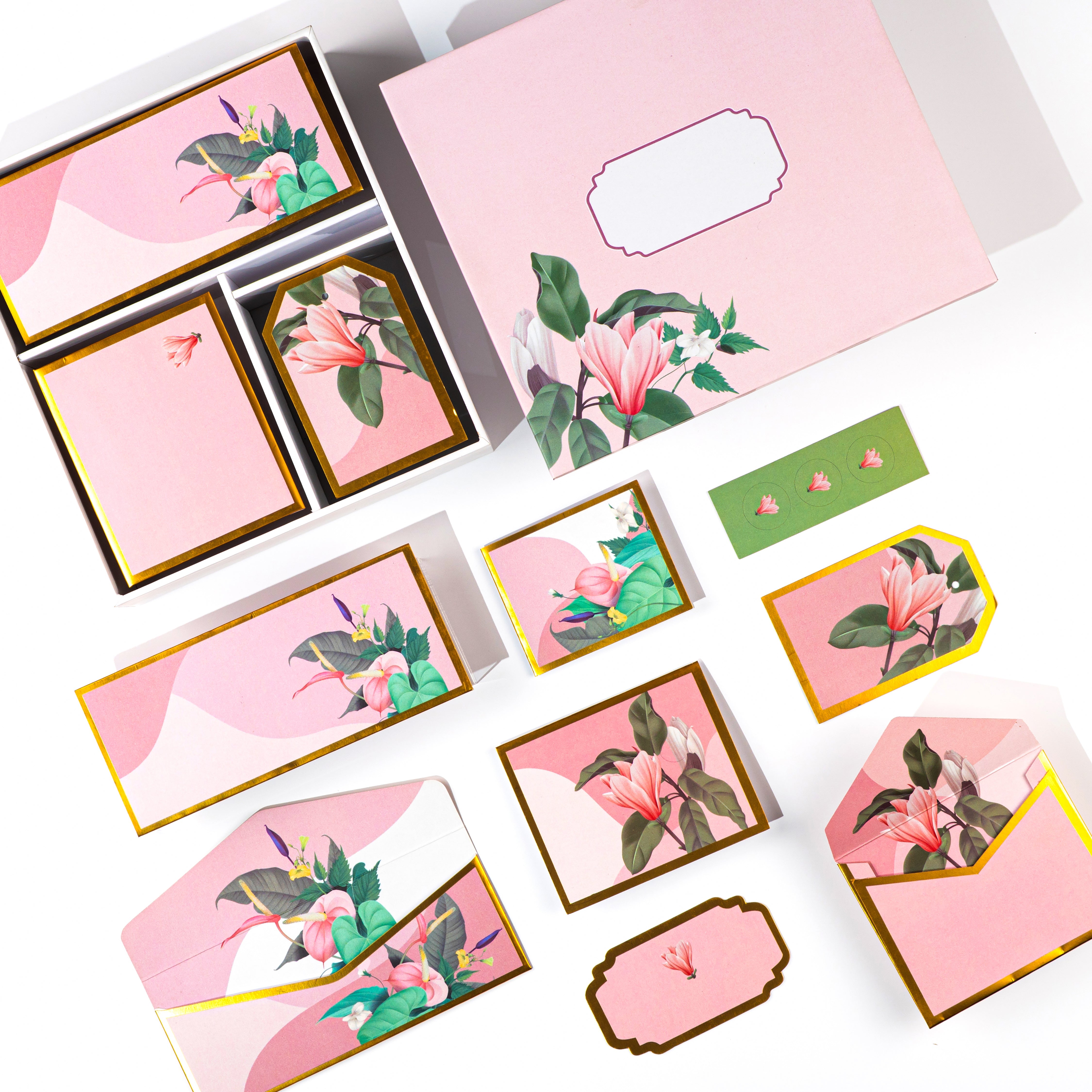 Elegant pink floral stationery set with lily illustrations, envelopes, tags, and folded cards.