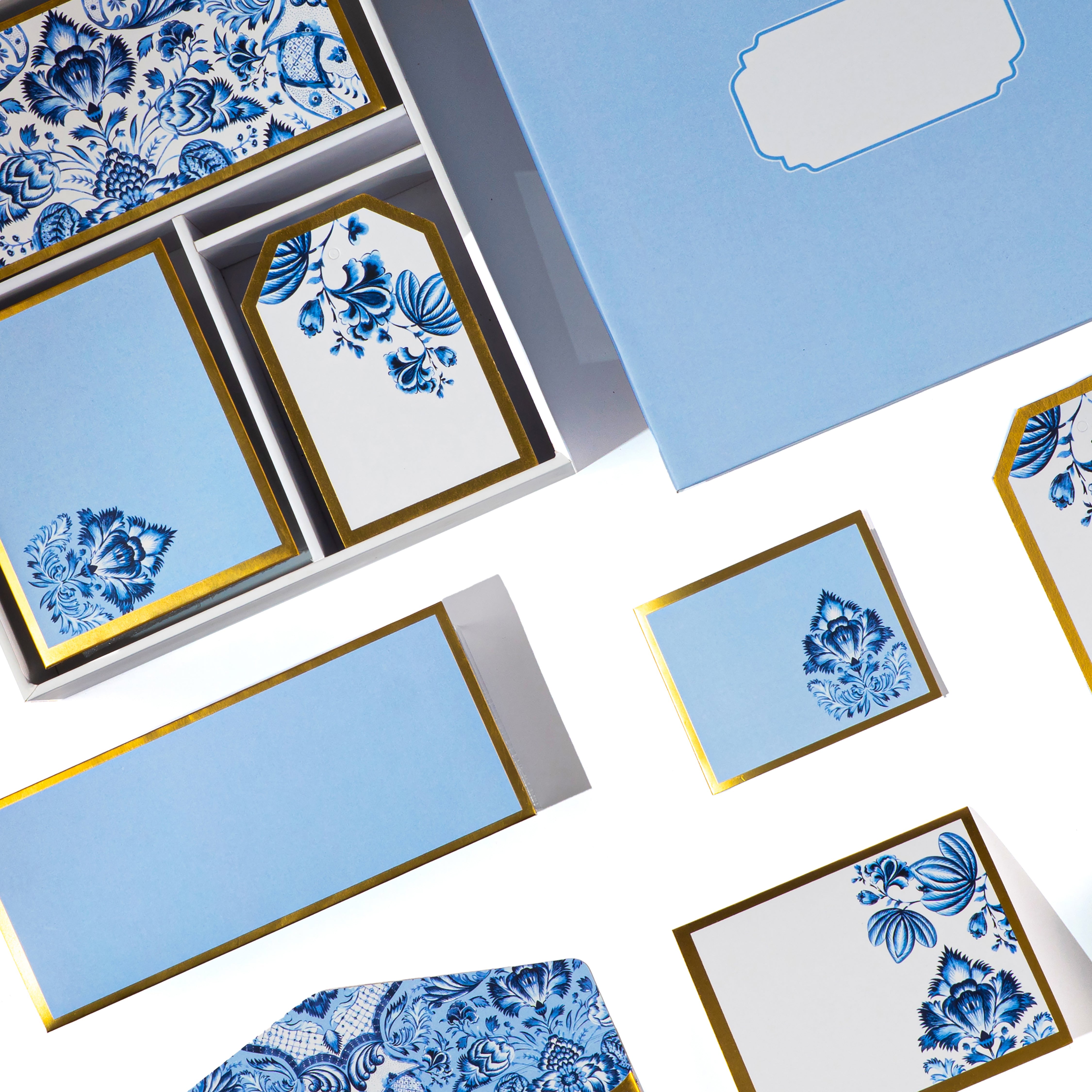 Blue and white Mughal floral stationery set with gold detailing, includes matching cards, tags, and envelopes.