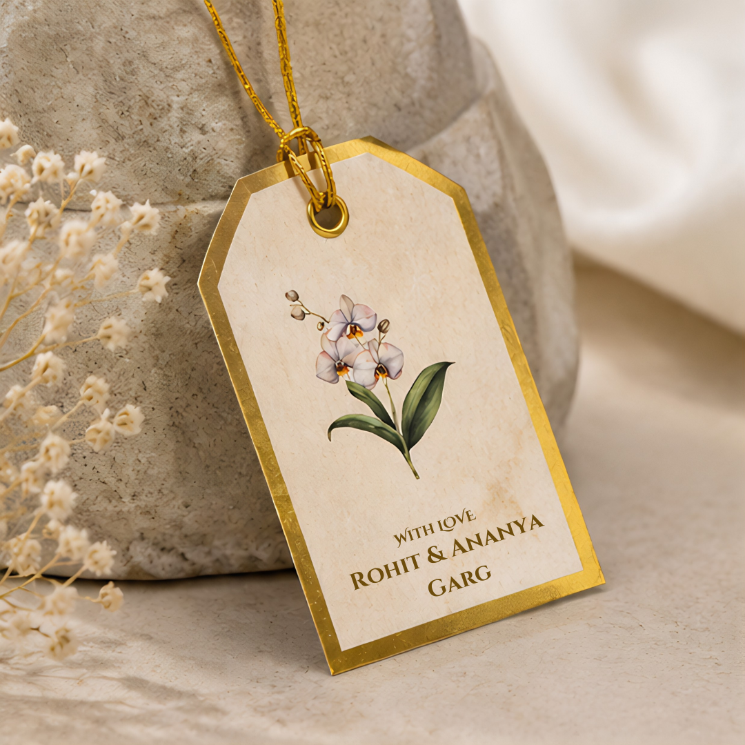 Elegant floral hanging tag with delicate orchid artwork, luxurious gold border, and matching golden dori for premium gifting.