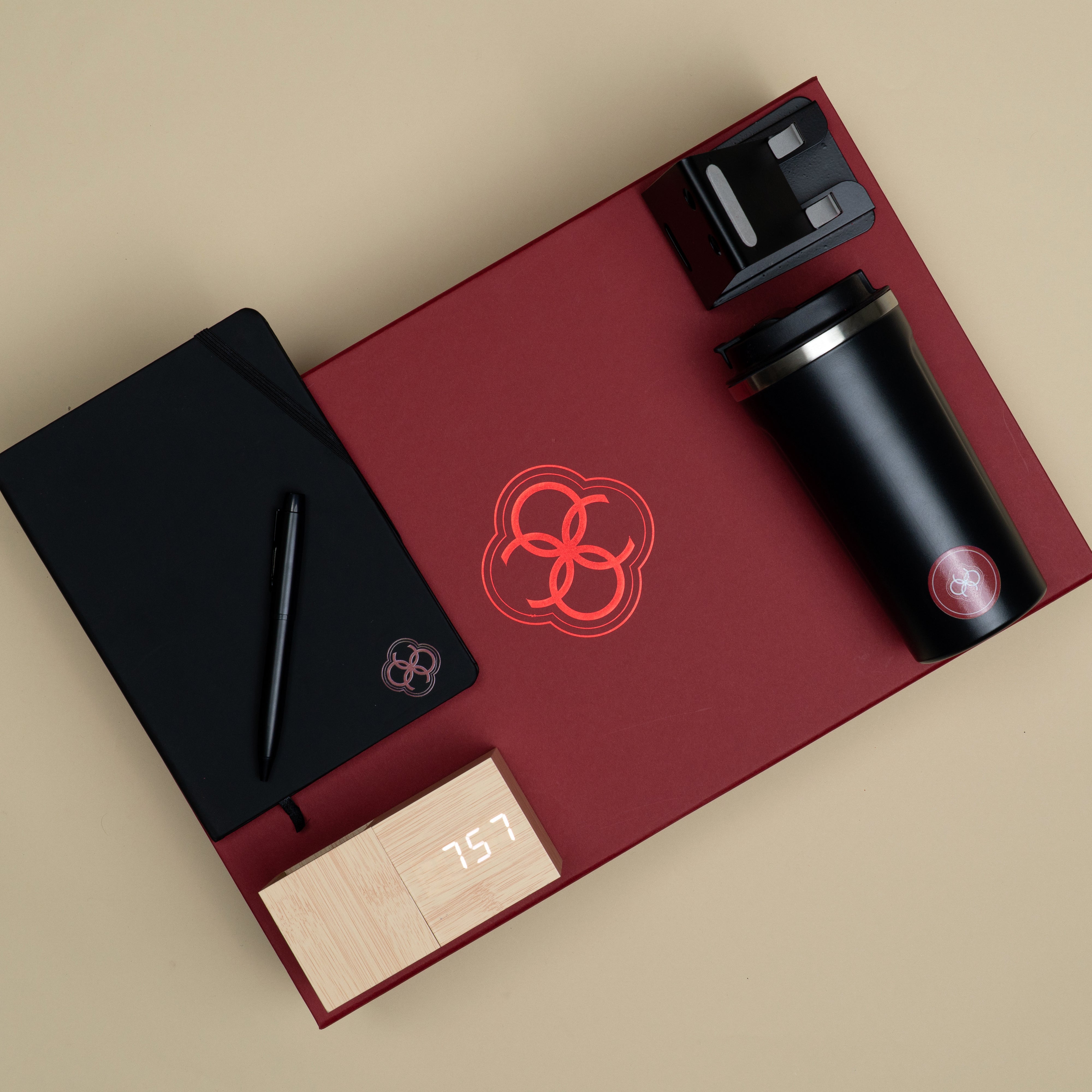Premium corporate gift set featuring a black temperature tumbler, black diary, black pen, phone stand and bamboo table clock with pen stand.