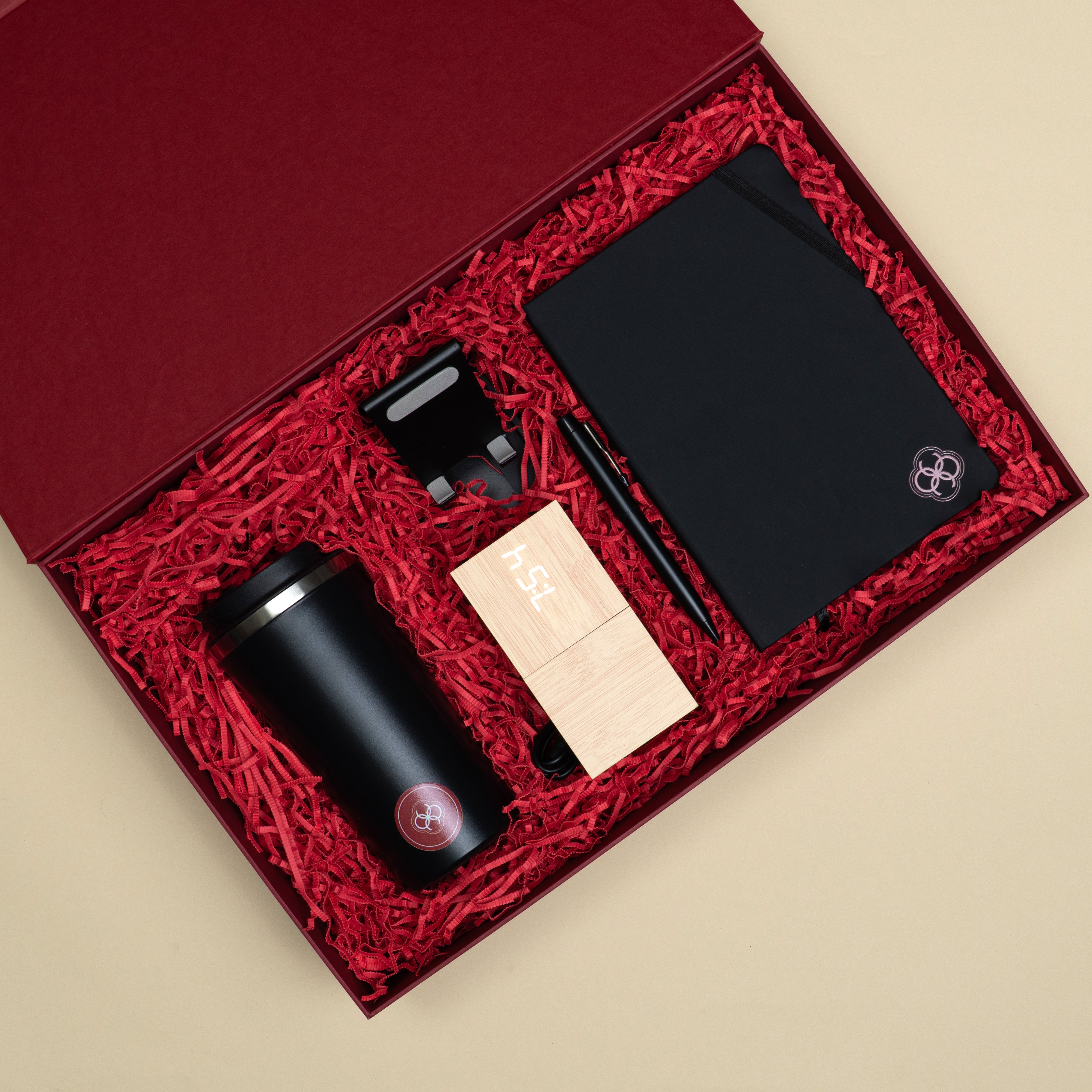 The Momentum corporate gifting set with black desk accessories, temperature tumbler and bamboo table clock packed in a premium red gift box.