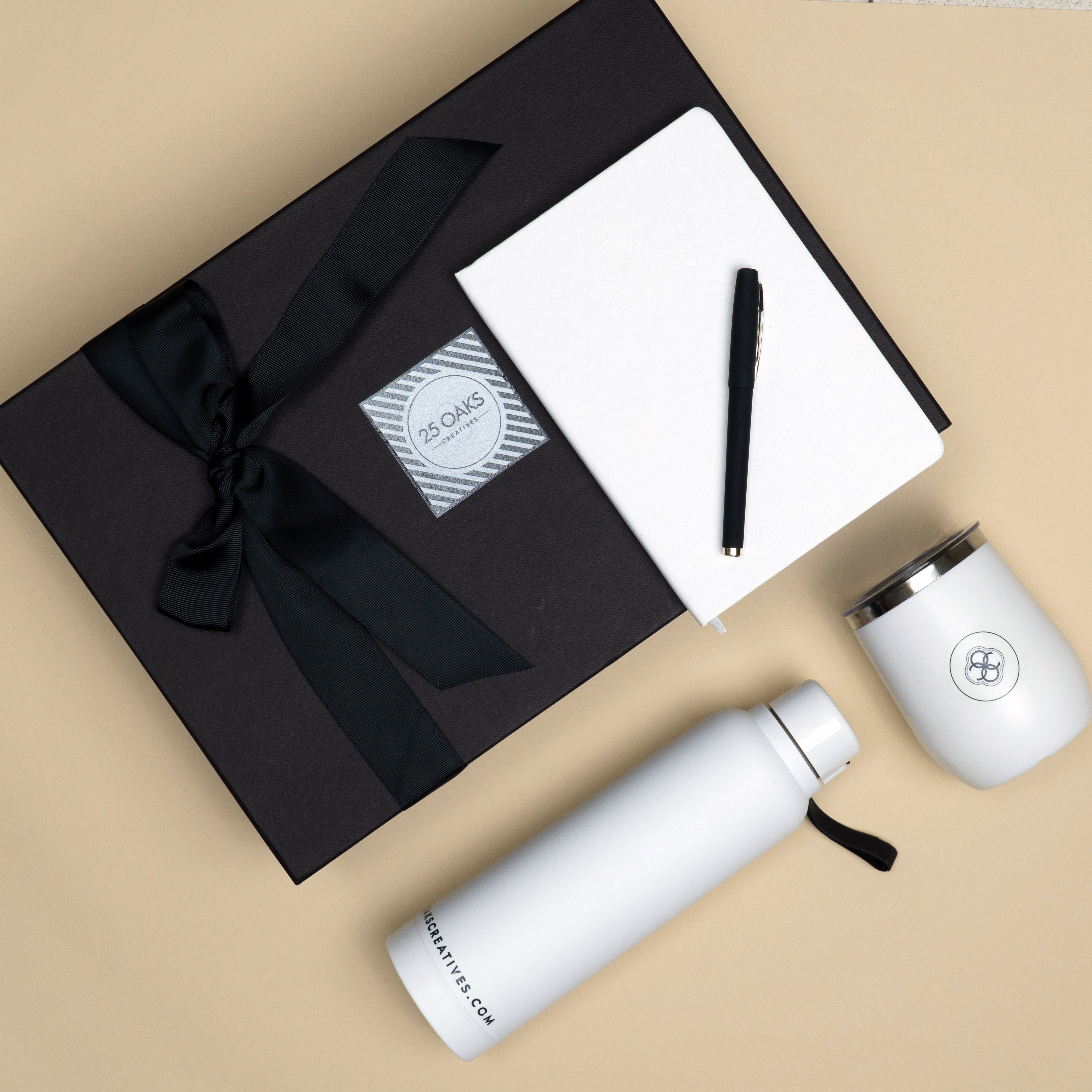 The Essentials corporate gift set with black pen, white A5 notebook, vacuum flask mug and white bottle in premium gift box.
