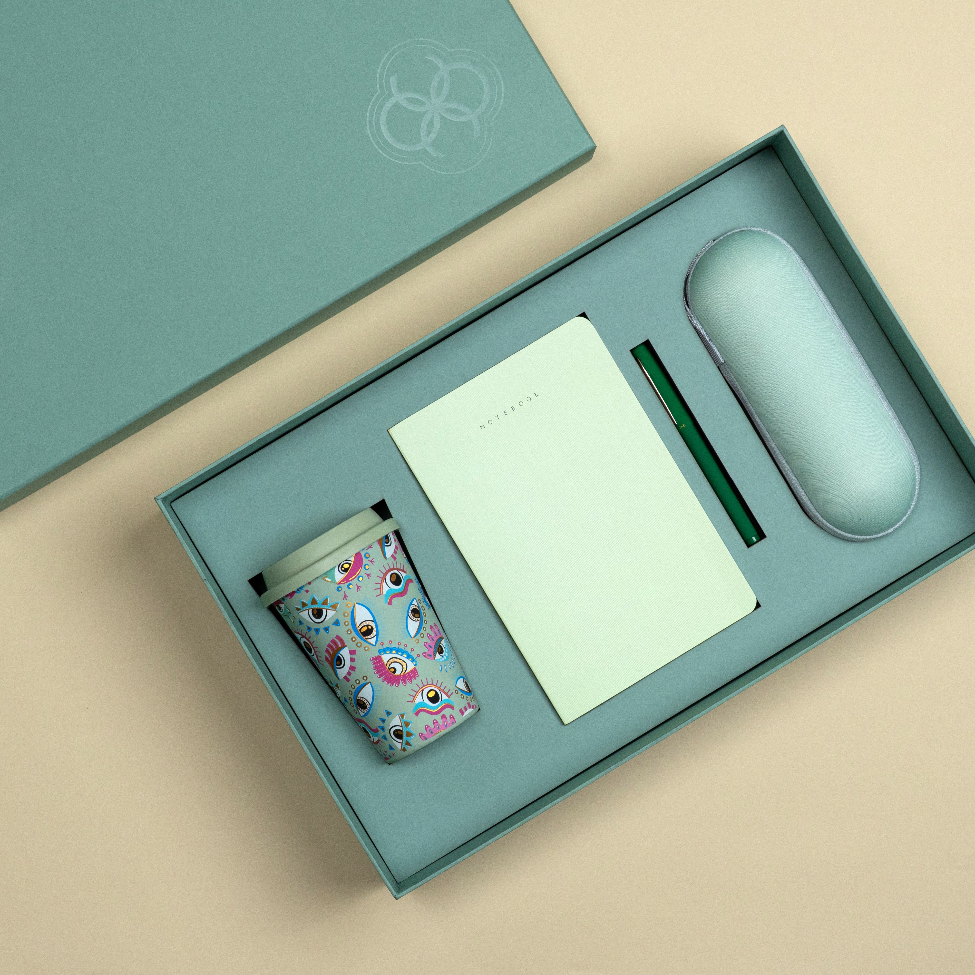 Premium sage green travel gift set featuring a tumbler, notebook, green pen and pocket-sized umbrella in a gift box.
