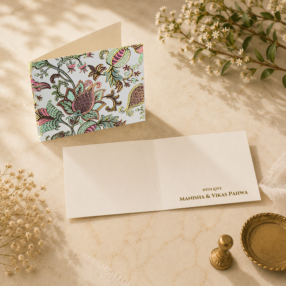 Luxury folded card with intricate chintz-inspired floral artwork in pastel tones styled with elegant ivory interiors and floral props.