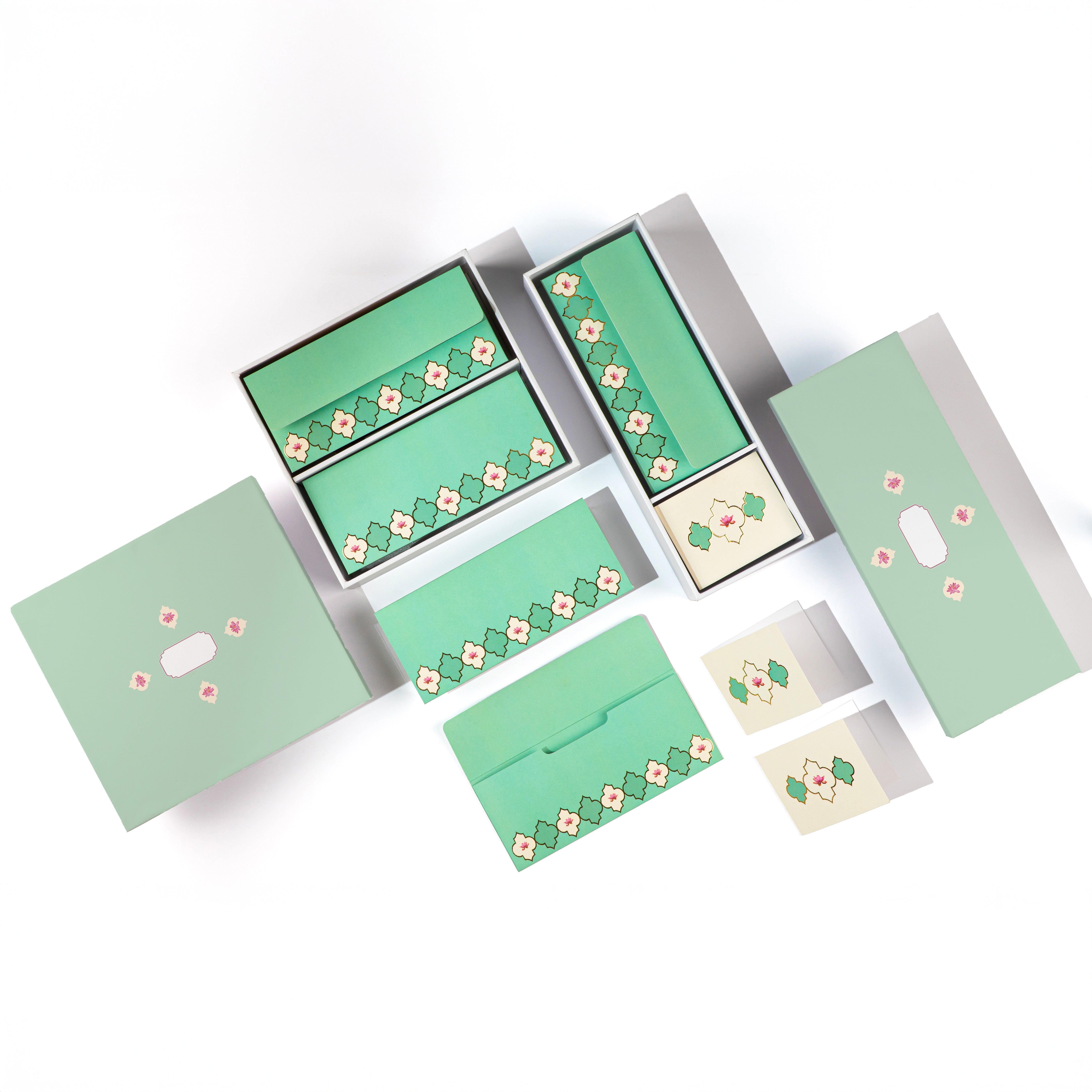 Pastel green floral stationery set with boxes, envelopes, and cards.

