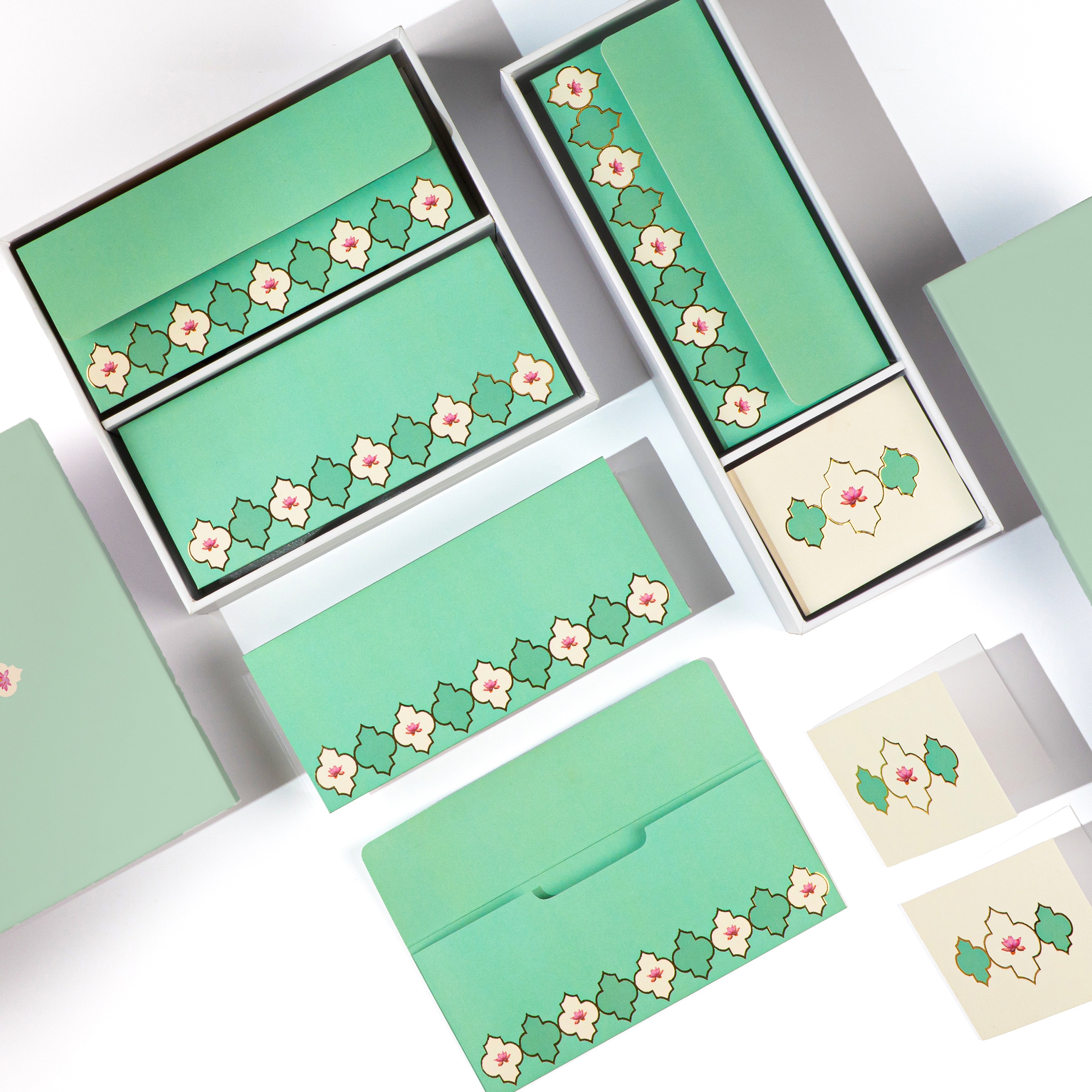 Pastel green floral stationery set with boxes, envelopes, and cards.

