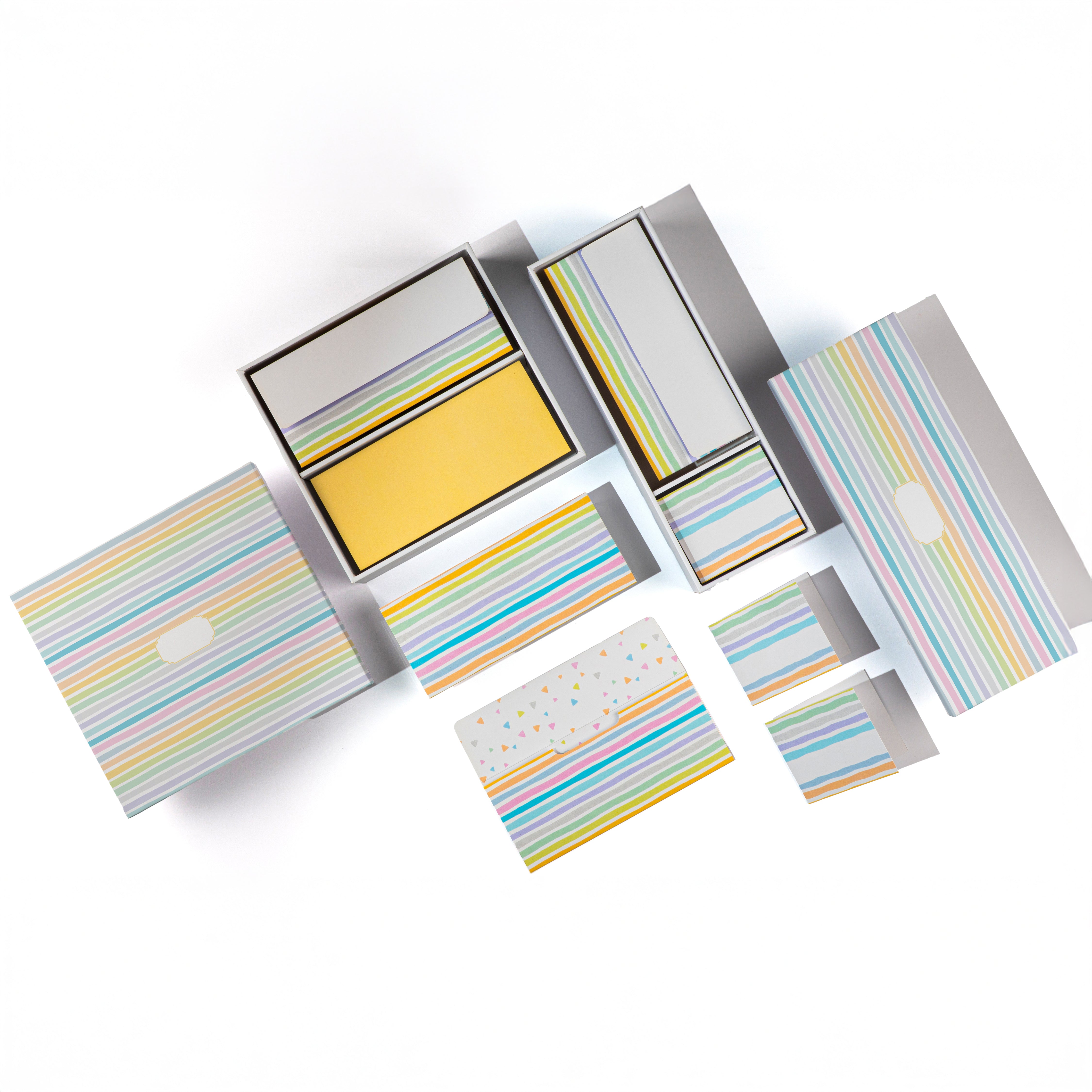 Colorful striped stationery set with envelopes, folded cards, and boxes in pastel tones.

