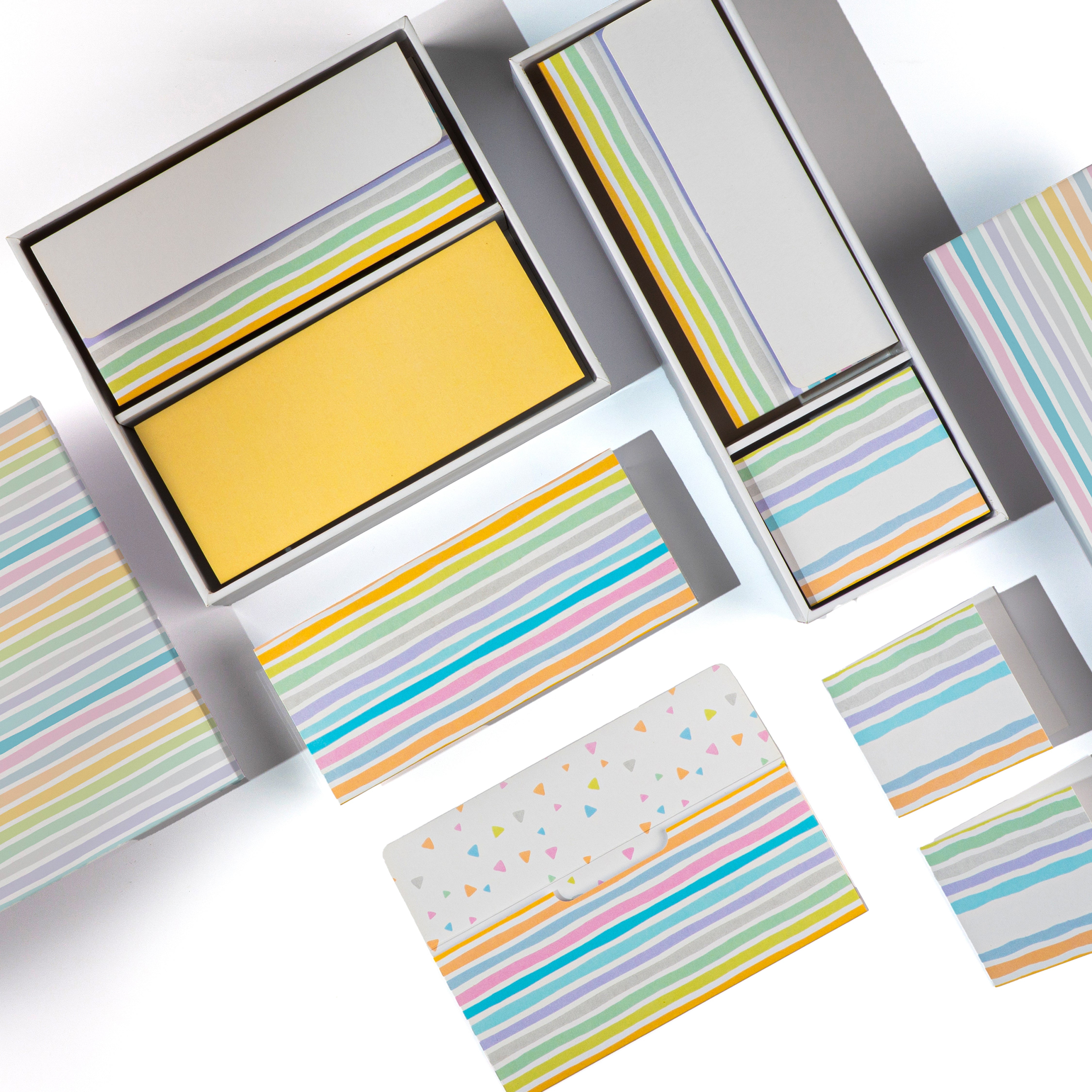 Colorful striped stationery set with envelopes, folded cards, and boxes in pastel tones.

